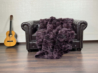 Fox fur throw blanket in purple with black details shown in natural light revealing depth and striking contrast
