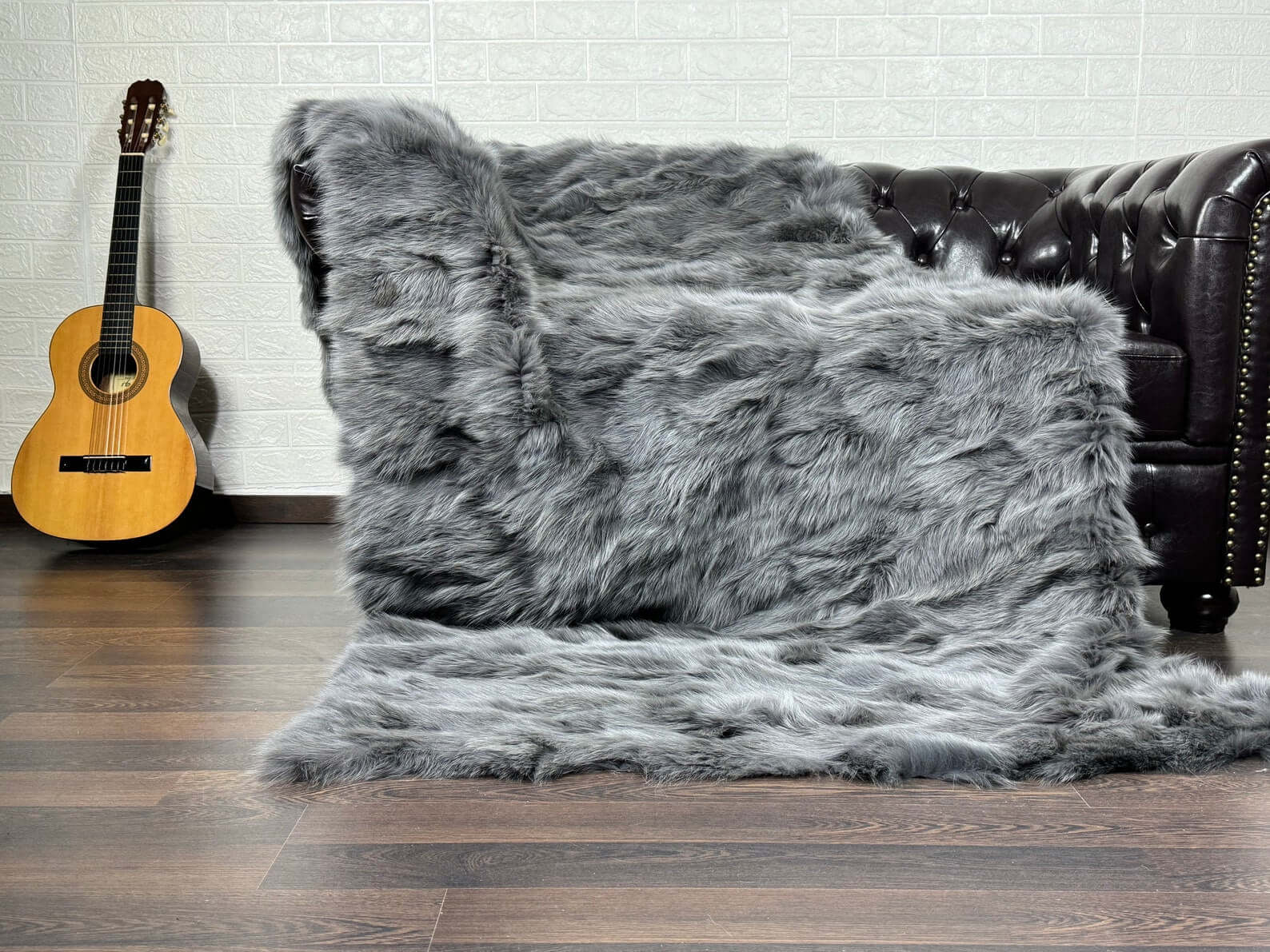 Fox Fur Blanket Throw Grey - Tatifurs displayed on a sofa, showcasing its luxurious soft texture and elegant gray color.
