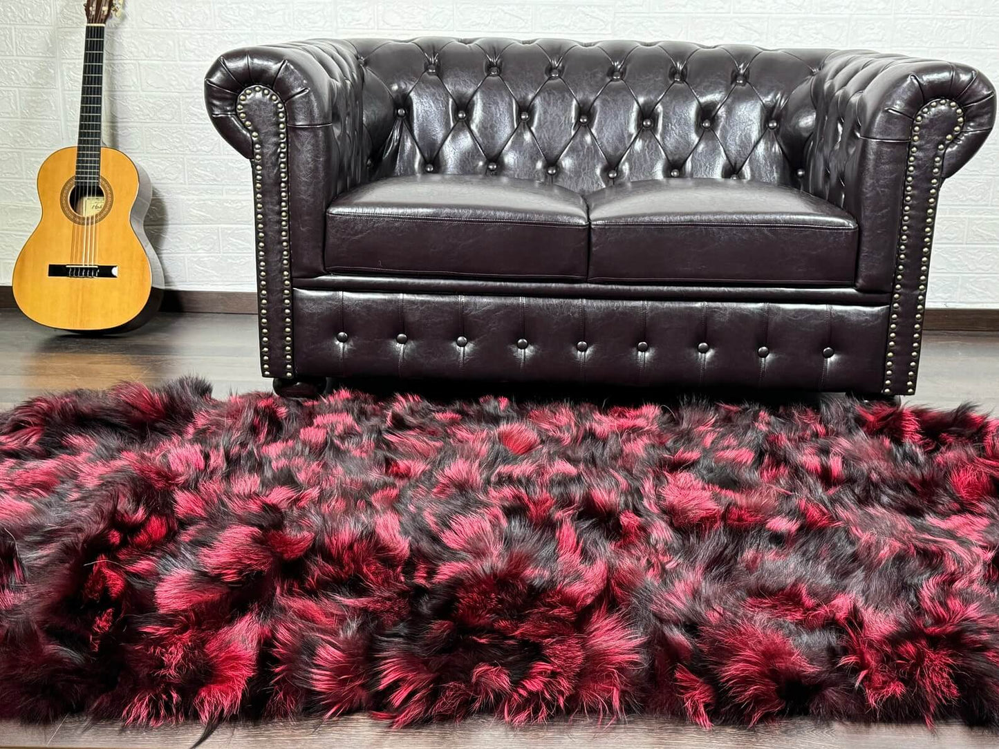Fox Fur Blanket Throw Black Red - Tatifurs displayed on a sleek leather sofa with a guitar in the background.