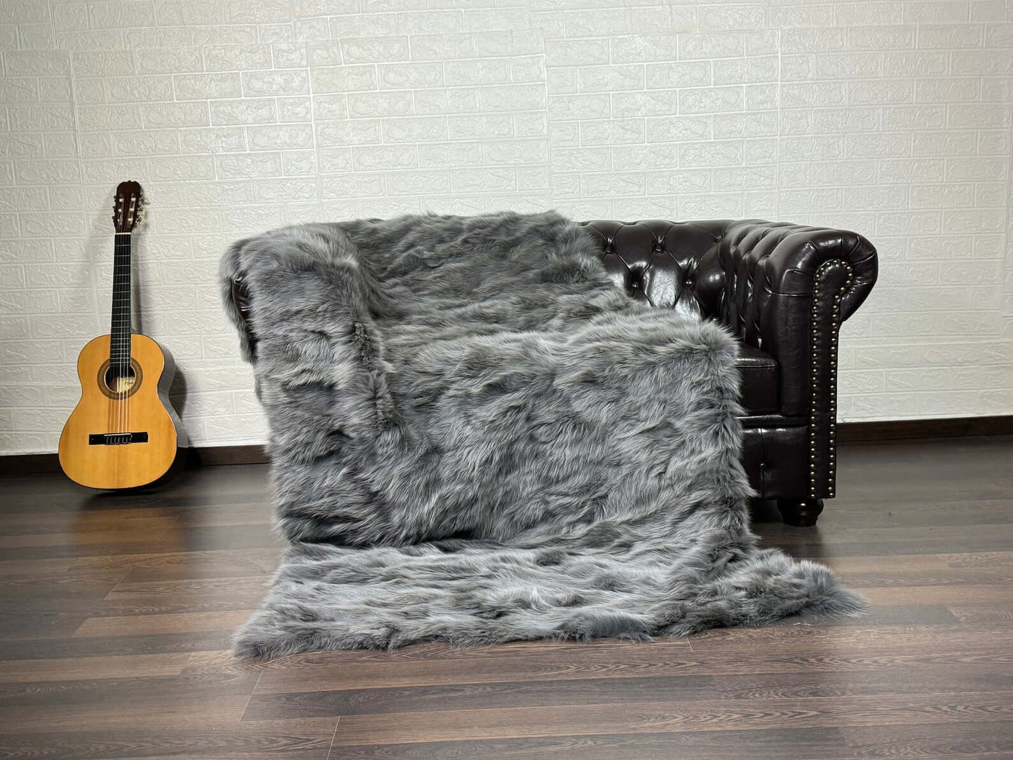 Fox Fur Blanket Throw Grey - Tatifurs on a vintage couch with a guitar in the background.