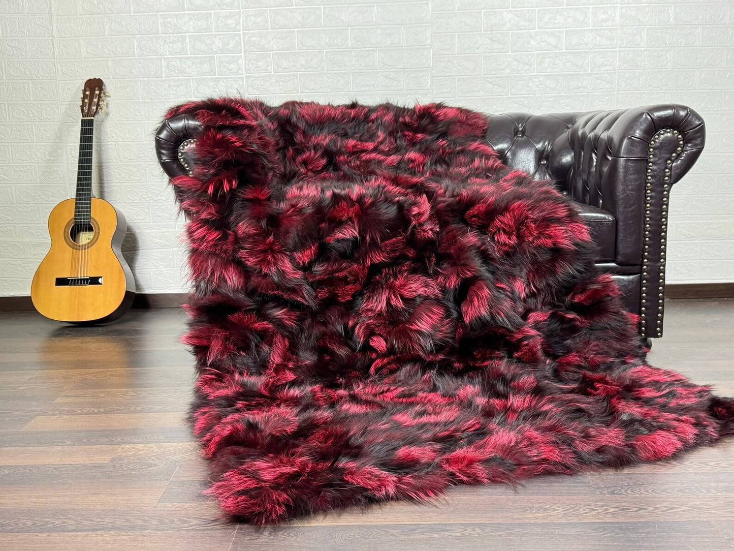 Fox Fur Blanket Throw Black Red - Tatifurs draped on a sofa, showcasing bold black and red fox fur texture.