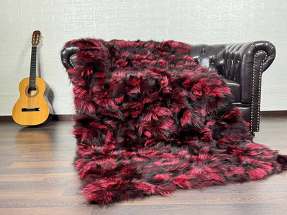 Fox Fur Blanket Throw Black Red - Tatifurs draped on a sofa, showcasing bold black and red fox fur texture.