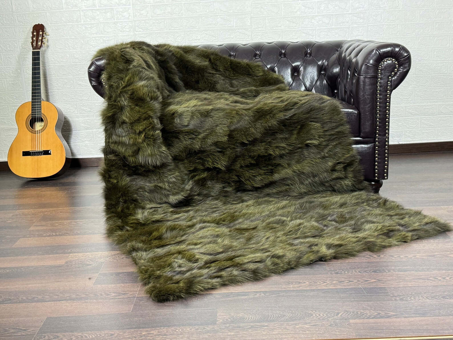 Fox Fur Blanket Throw Green - Tatifurs draped over a sofa, showcasing long flowing fur in deep green.