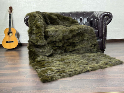 Fox Fur Blanket Throw Green - Tatifurs draped over a sofa, showcasing long flowing fur in deep green.