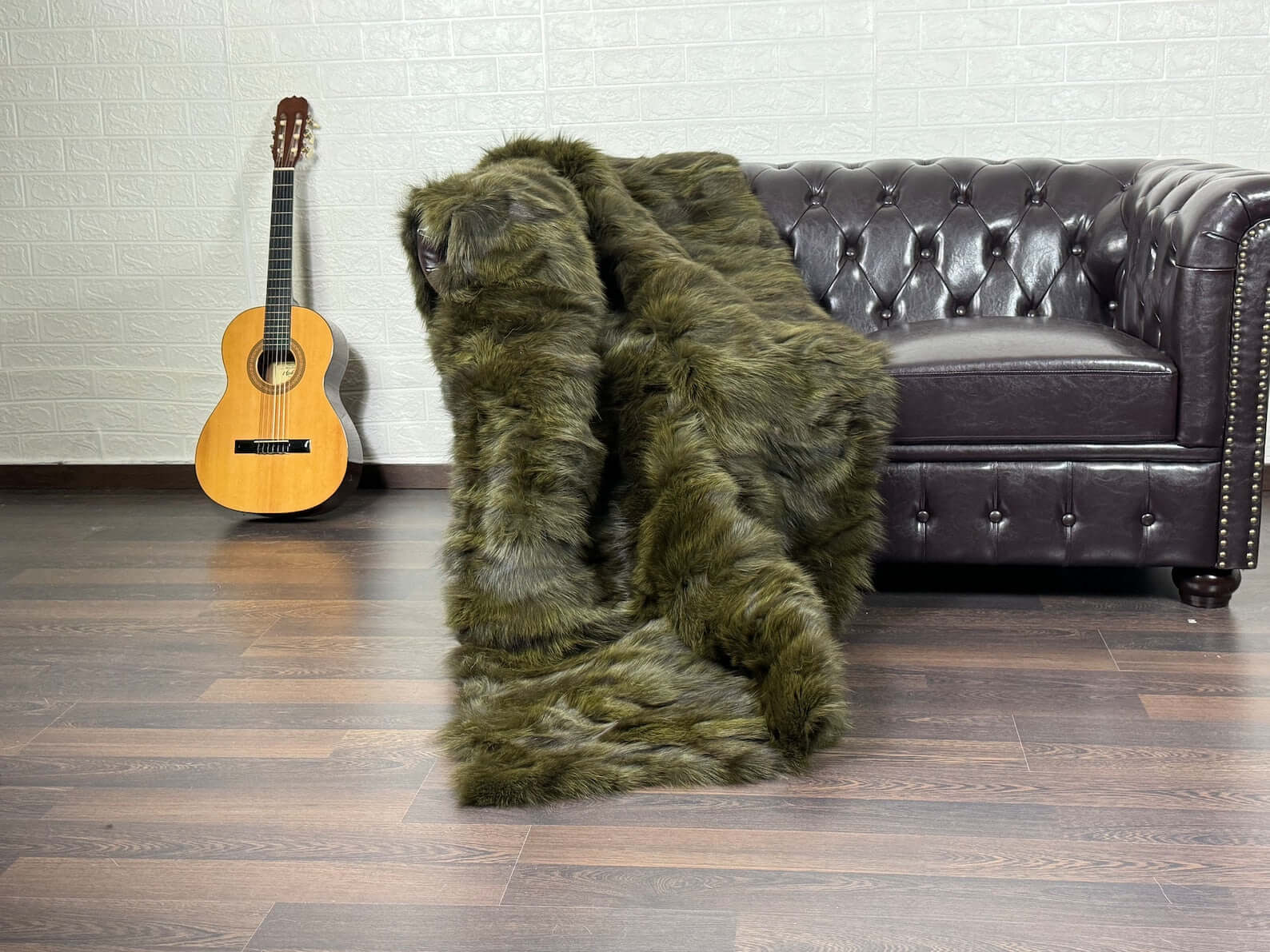 Fox Fur Blanket Throw Green - Tatifurs displayed on a couch with an acoustic guitar in the background.