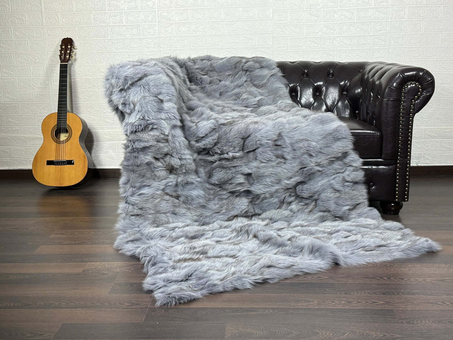 Fox Fur Blanket Throw Bluejean - Tatifurs draped over a couch, showcasing luxurious fox fur texture and denim blue color.