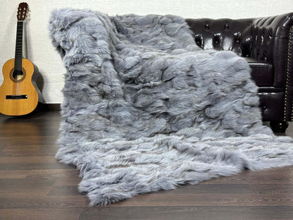 Fox Fur Blanket Throw Bluejean - Tatifurs displayed on a couch with acoustic guitar, showcasing luxurious faux fur texture.