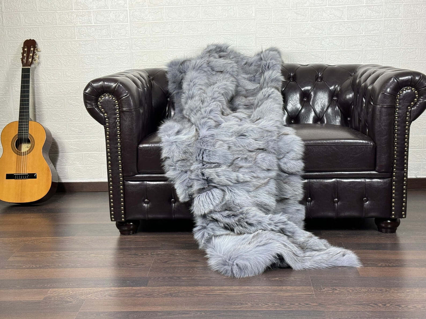 Fox Fur Blanket Throw Bluejean - Tatifurs draped over a luxurious leather sofa.