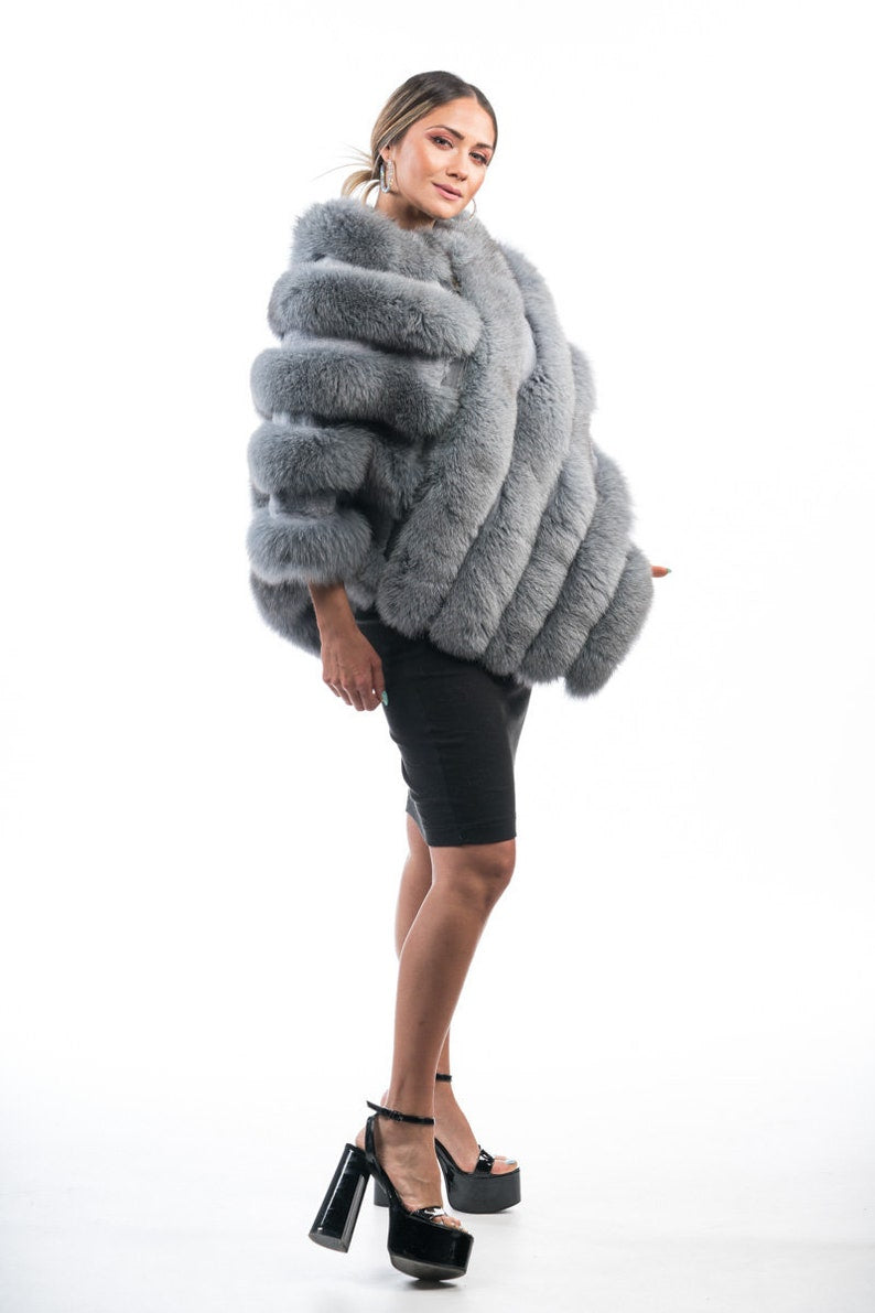Fox fur poncho gray shown from the back fox side displaying full hip level poncho silhouette and diagonal full skin gray fox strip surface — Greek craftsmanship, TatiFurs
