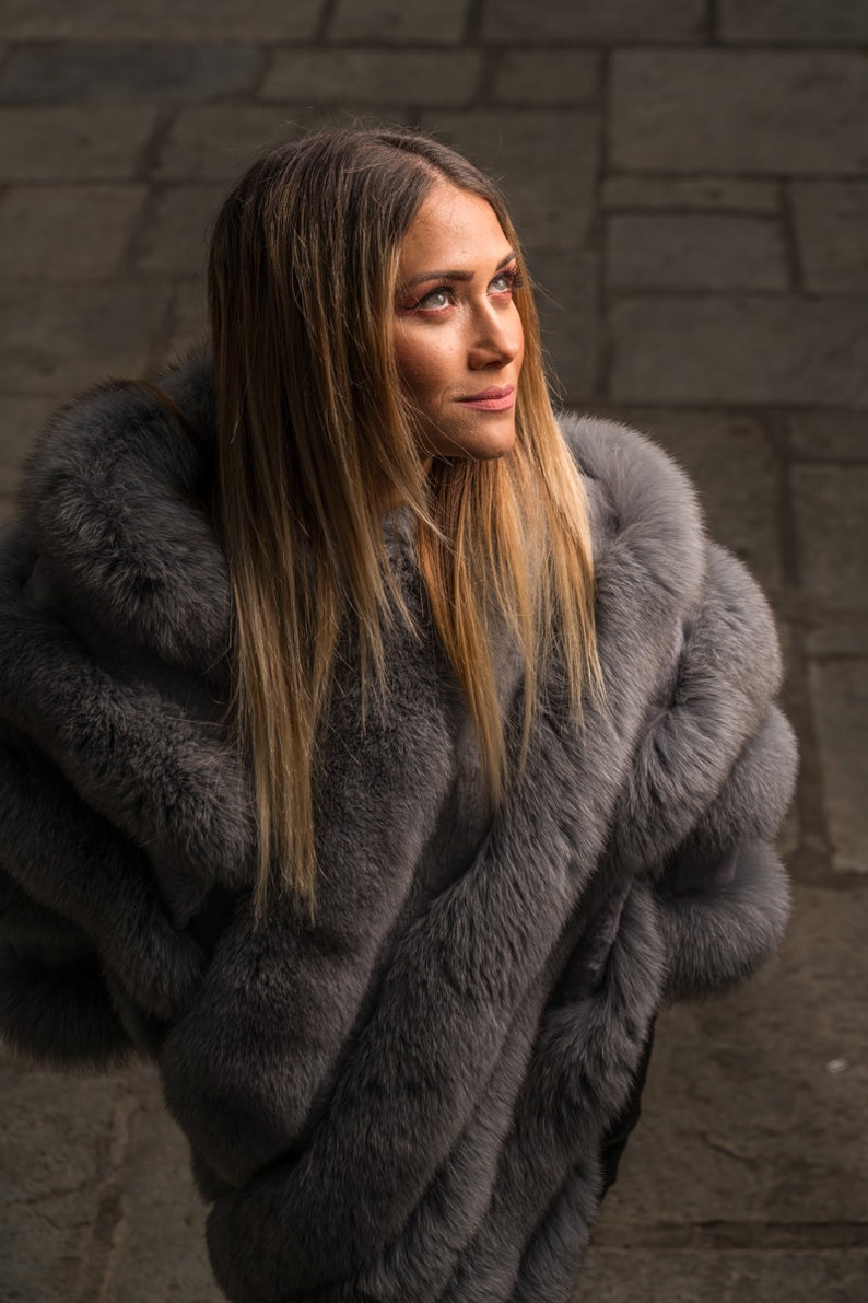 Fox fur poncho gray shown from the side displaying hip level poncho silhouette and diagonal gray fox strip construction — Greek craftsmanship, TatiFurs
