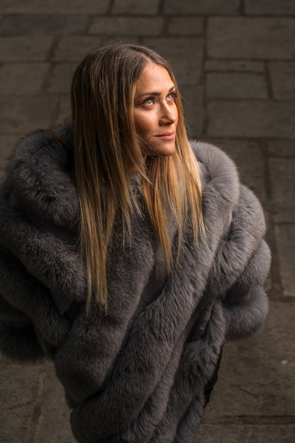 Fox fur poncho gray shown from the side displaying hip level poncho silhouette and diagonal gray fox strip construction — Greek craftsmanship, TatiFurs
