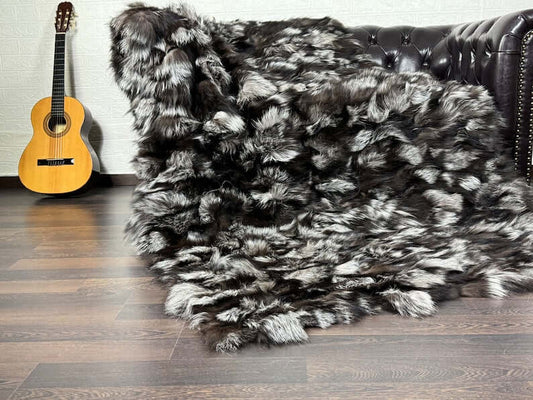 Fox Fur Blanket Throw Double Sided Silver - Tatifurs draped over a couch beside a guitar.
