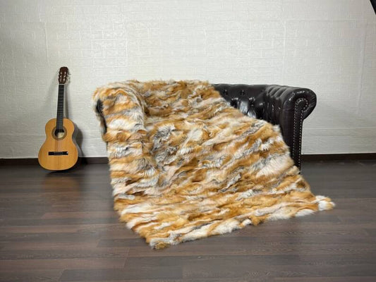 Fox Fur Blanket Throw Red Canadian - Tatifurs displayed on a couch with a guitar in the background.