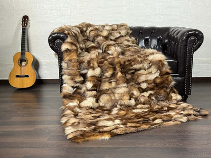 Fox Fur Blanket Throw Crystal Natural - Tatifurs draped over a leather couch with a guitar in the background.
