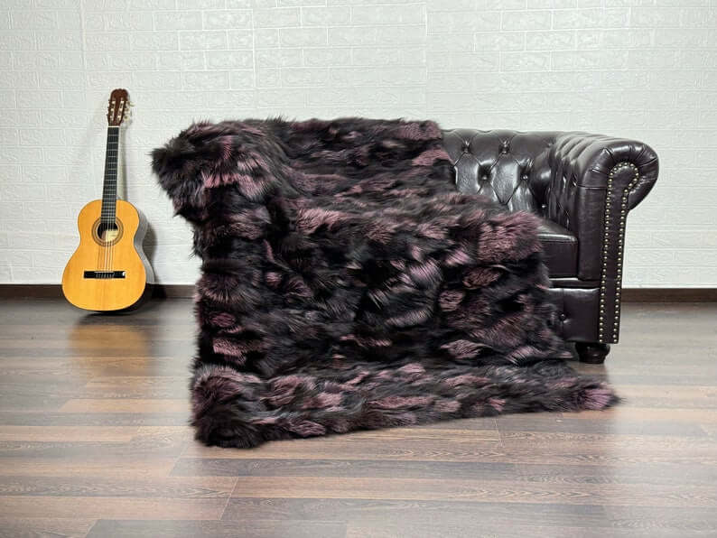 Fox Fur Blanket Throw Black Purple  - Tatifurs draped on a classic leather couch with a guitar.