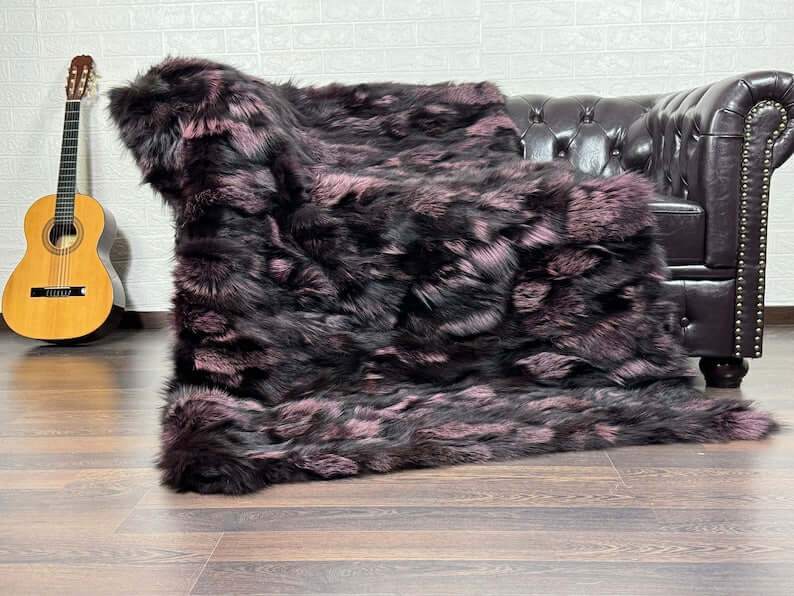 Fox Fur Blanket Throw Black Purple - Tatifurs draped on a sofa, showcasing luxurious black and purple hues.