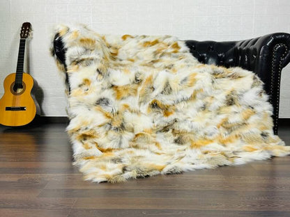 Fox Fur Blanket Throw Golden - Tatifurs displayed on a plush couch with a guitar in the background, showcasing its warm golden tones.