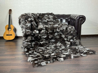 Fox Fur Blanket Throw Silver - Tatifurs on a sofa, showcasing its luxurious natural silver fox fur texture.