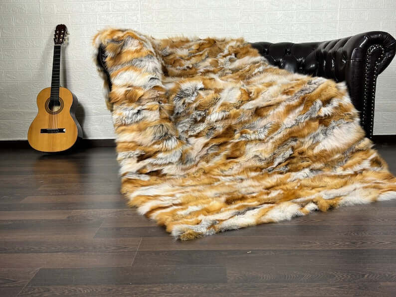 Fox Fur Blanket Throw Red Canadian - Tatifurs on a couch with a guitar in the background.