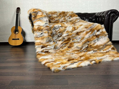 Fox Fur Blanket Throw Red Canadian - Tatifurs on a couch with a guitar in the background.