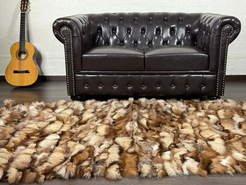 Fox Fur Blanket Throw Crystal Natural - Tatifurs on a floor in front of a brown leather couch with a guitar.