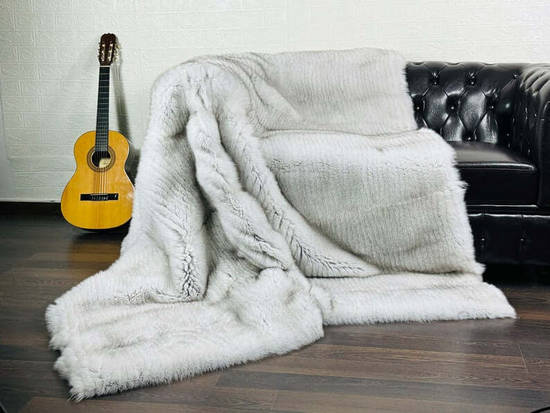 Natural blue fox fur full skin blanket draped over sofa showing rare sophisticated interior statement
