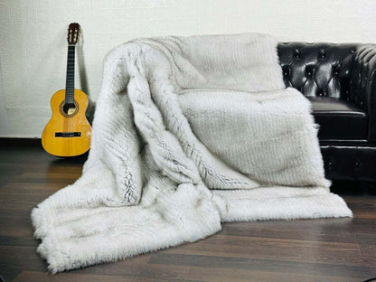 Natural blue fox fur full skin blanket draped over sofa showing rare sophisticated interior statement
