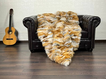 Fox Fur Blanket Throw Red Canadian - Tatifurs draped on a leather sofa with an acoustic guitar in the background.