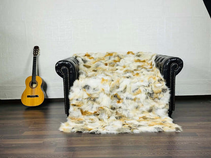 Fox Fur Blanket Throw Golden - Tatifurs draped over black leather couch with guitar nearby.