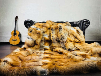 Fox Fur Blanket Throw Gold Saga Fox Natural - Tatifurs draped over a couch with a guitar in the background.