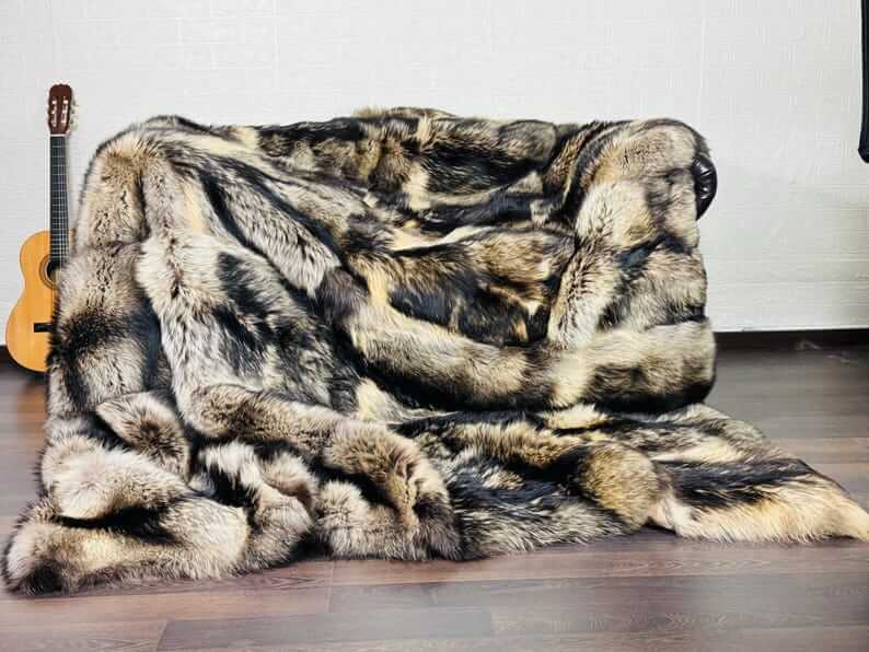 Fin Raccoon Blanket Throw Fur Natural - Tatifurs on a sofa, showcasing luxurious beige and black tones.