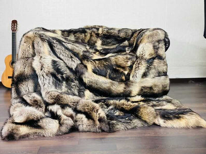 Fin Raccoon Blanket Throw Fur Natural - Tatifurs on a sofa, showcasing luxurious beige and black tones.