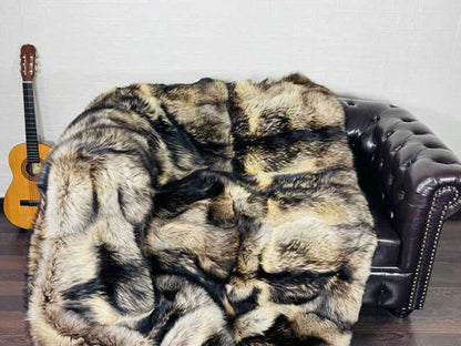 Fin Raccoon Blanket Throw Fur Natural - Tatifurs draped on a leather couch, showcasing stunning beige and black tones.