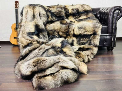 Fin Raccoon Blanket Throw Fur Natural - Tatifurs draped over a sofa with a guitar in the background.