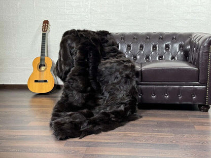 Fox Fur Blanket Throw Brown - Tatifurs draped over a sofa with a guitar nearby, showcasing luxurious texture.