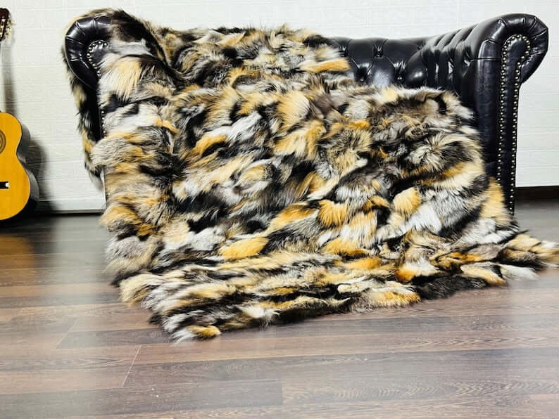 Fox Fur Blanket Throw Double Sided Gross Natural in orange, black, and silver colors on a sofa.