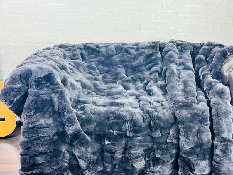 Rabbit Blanket Throw Rex Gray - Tatifurs on a cozy couch, showcasing its luxurious and warm texture.