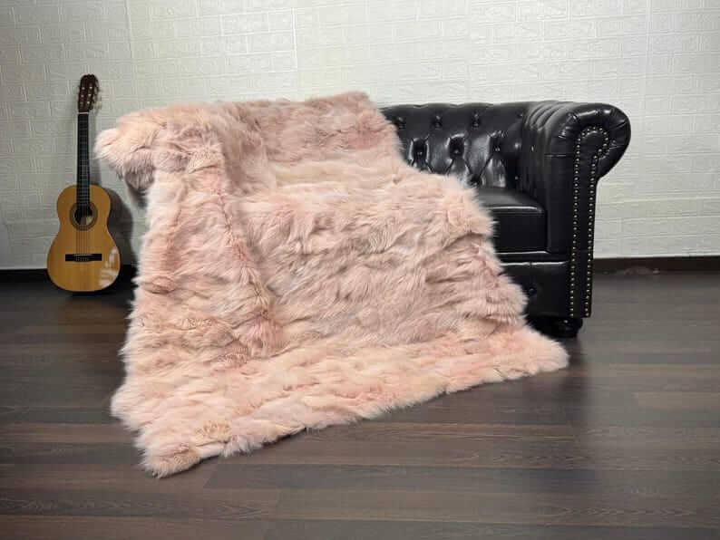 Fox Fur Blanket Throw Baby Pink - Tatifurs on a sofa, soft and luxurious, ideal for cozying up in style.
