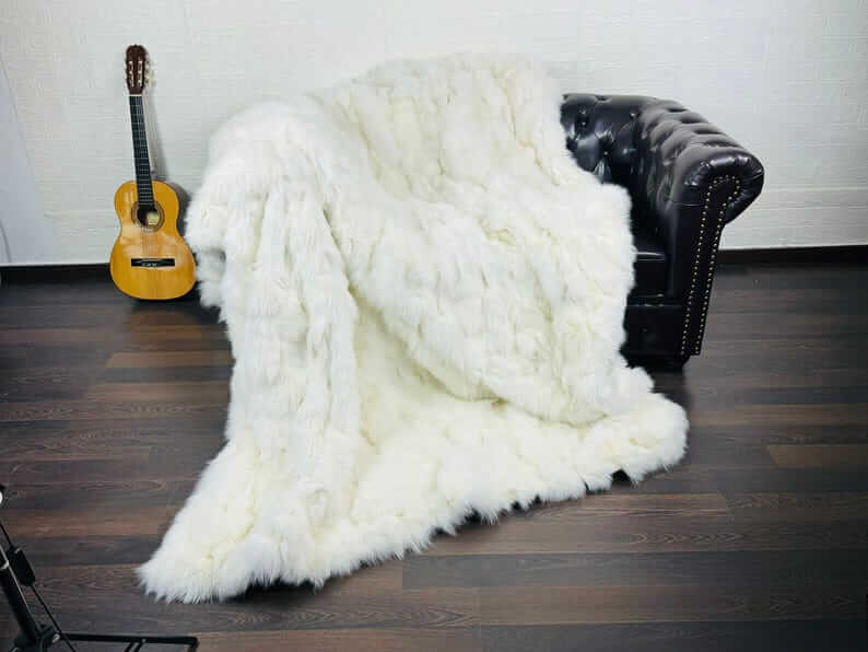 Fox fur blanket throw white draped across a bed showing pure luminous white tone and natural long pile movement in soft light
