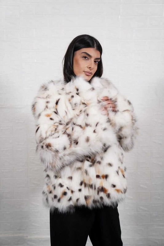 Woman wearing white fox fur coat with bold leopard print collar
