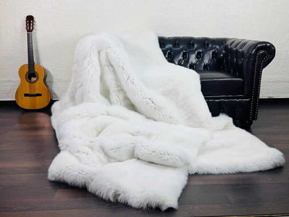 White Fox Fur Throw Blanket - Tatifurs on a couch next to a guitar, showcasing luxurious white fox fur.