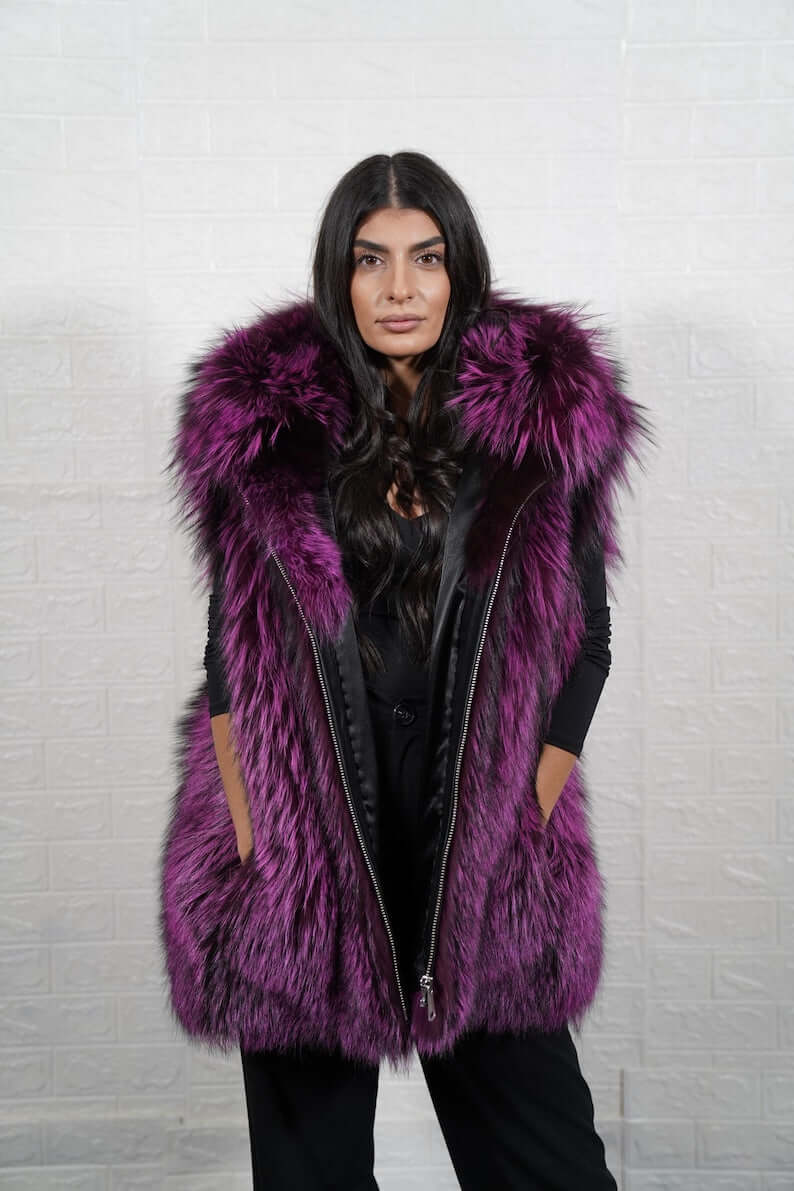 Woman wearing purple and black fox fur hooded vest with zipper closure
