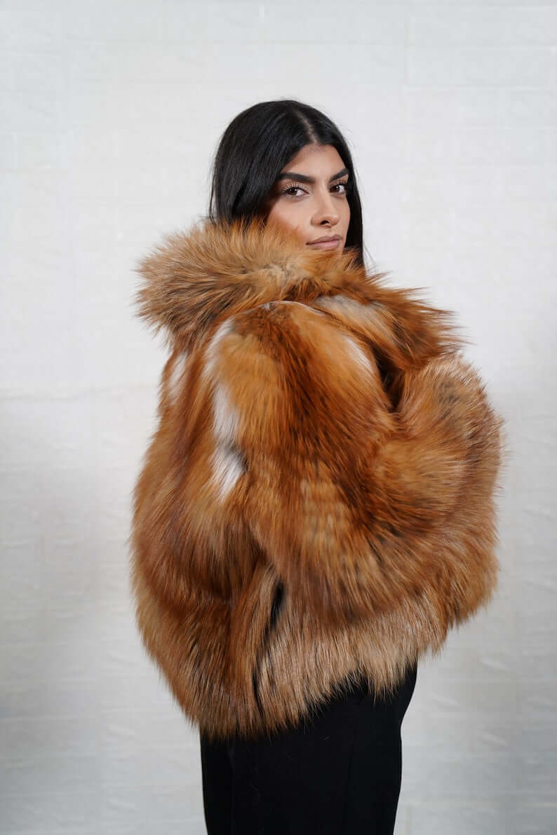 Golden fox fur short jacket displayed on hanger
