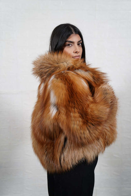 Golden fox fur short jacket displayed on hanger
