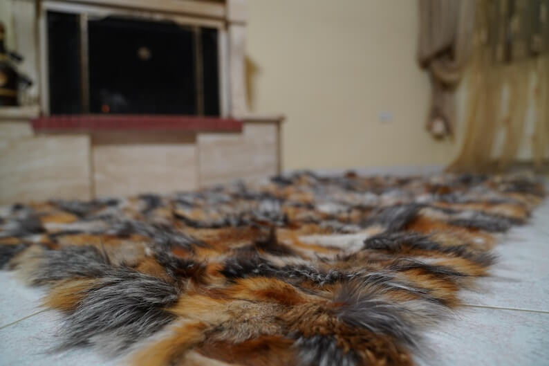 Fur Throw Blanket Natural Gross Fox – Luxury - Tatifurs displayed elegantly on the floor, showcasing its dramatic texture and colors.