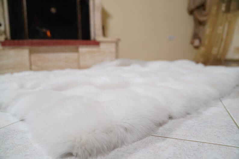 White Fox Fur Throw Blanket - Tatifurs laid out elegantly on the floor, showcasing its luxurious texture and pristine color.