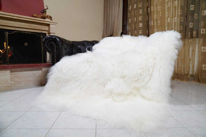 White Wool Sheepskin Mongolian Blanket Throw - Tatifurs draped elegantly over a stylish sofa, showcasing its luxurious texture.