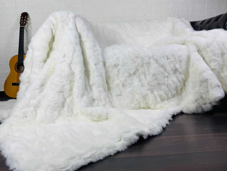 White Rabbit Fur Throw Blanket - Tatifurs draped over a sofa, showcasing its luxurious texture and softness.