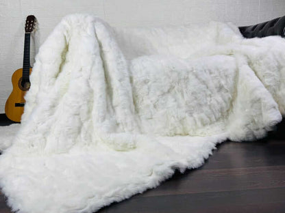 White Rabbit Fur Throw Blanket - Tatifurs draped over a sofa, showcasing its luxurious texture and softness.