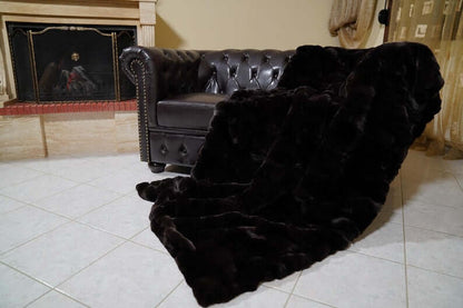 Rabbit Blanket Throw Rex Dark Brown - Tatifurs displayed on a stylish black couch in a cozy living room.